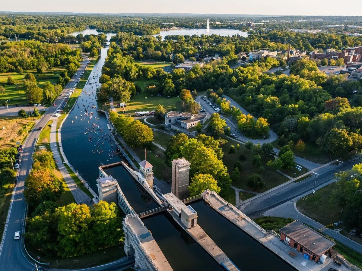 A scenic view of the Trent-Severn Waterway, featuring calm waters, lush greenery, and a historic lock. Visitors can reserve a tour to explore the Trent-Severn and other beautiful locations. Experience the natural beauty and historical significance of these waterways through our guided tours.