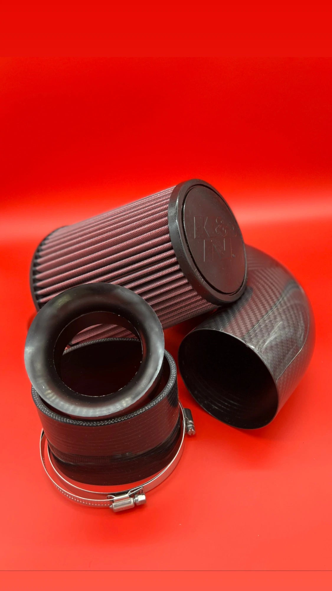 The image shows the same item, but it is broken down into three sections, including a K&G Sea-Doo Carbon Fiber Cold Air Intake with K&G Filter, a high-performance modification for Sea-Doo watercrafts. This lightweight carbon fiber intake system incorporates a K&G filter that maximizes airflow and improves engine performance. The combination increases throttle responsiveness and power output while maintaining a clean, modern appearance.