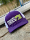 Toronto Jet Ski Trucker Hat: Front panel in vibrant purple with white embroidered 'Toronto' and neon yellow 'jetski' logo. Back features breathable white mesh material. Neon stitching accents the brim, adding a pop of color to this stylish watersport accessory.